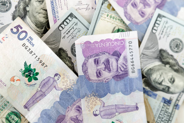 Close-up of bills of 50 thousand Colombian pesos and bills of 100 dollars