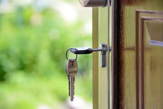 pexels-photo-101808-101808 Key inserted in door lock against a blurred green background, symbolizing security and real estate.